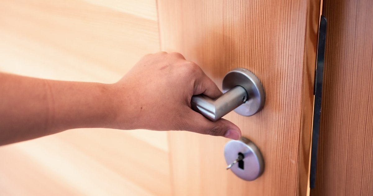 Porte d'entrée en bois avec main sur la poigner