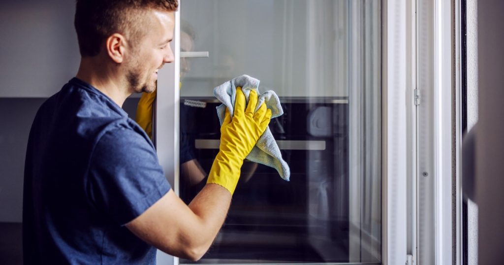 professionnel nettoyant une fenêtre pvc blanche