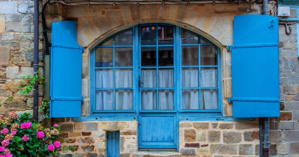 Fenêtre bois à petits bois bleu posée sur une façade à pans de bois du centre historique de Vitré