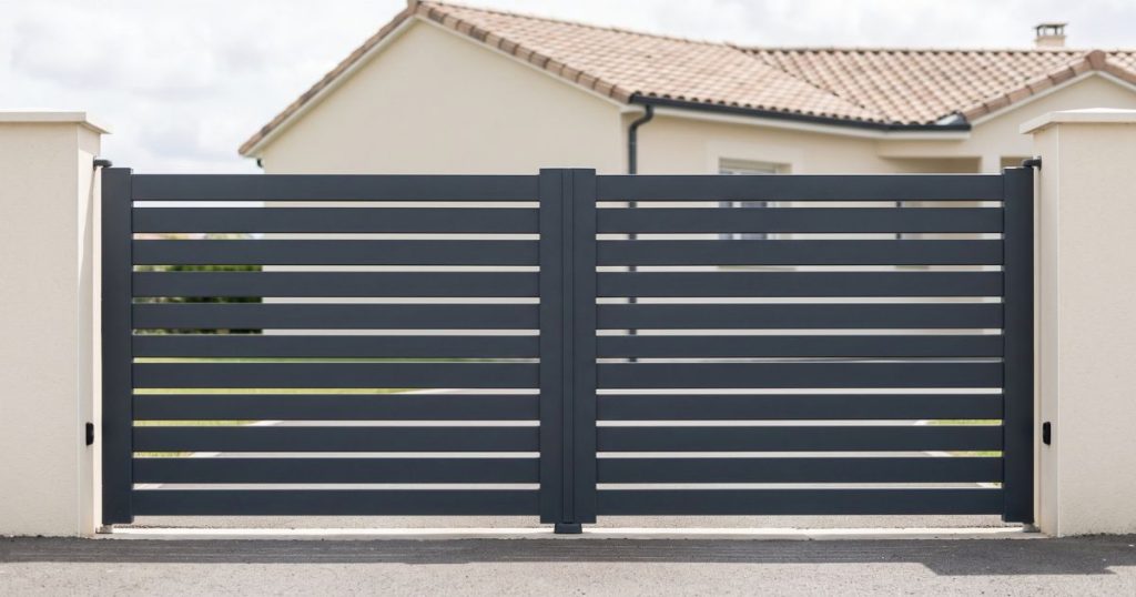 Portail battant aluminium fermé sur ses deux vantaux joints, vu de face depuis la rue
