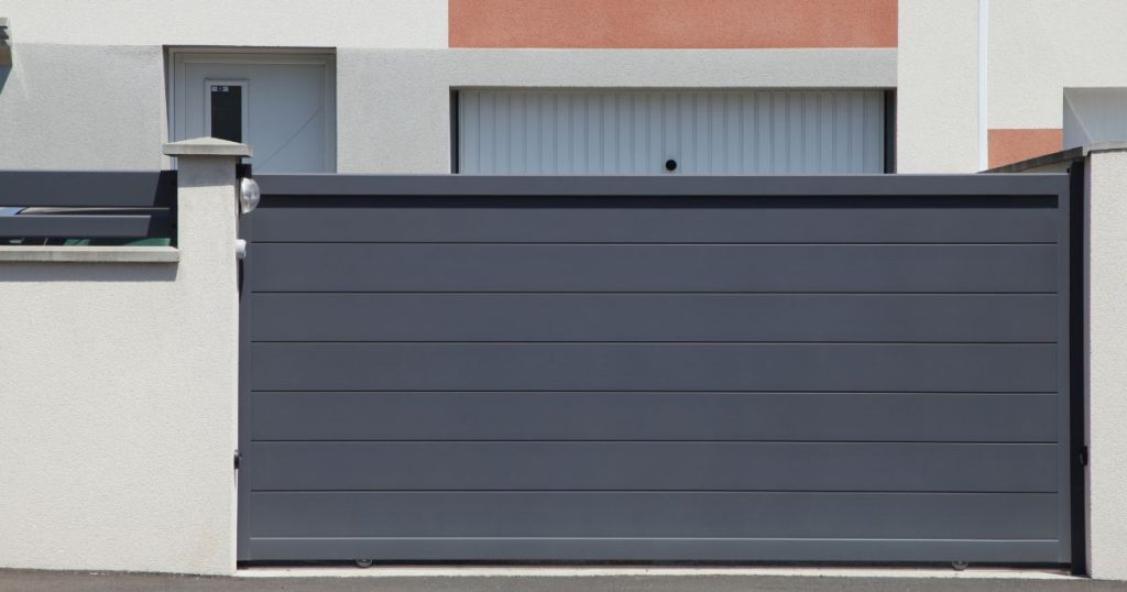 Portail coulissant à Montigné-le-Brillant, tablier aluminium effacé le long de la clôture, par Kalio Menuiserie
