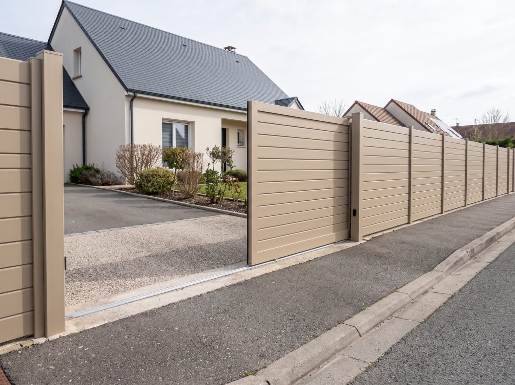 Portail coulissant aluminium ouvert, tablier effacé le long de la clôture, passage dégagé