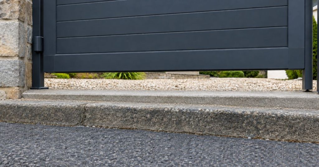 Seuil d’une entrée en contre-haut de la rue à Saint-Jean-sur-Mayenne, garde au sol du portail visible, par Kalio Menuiserie